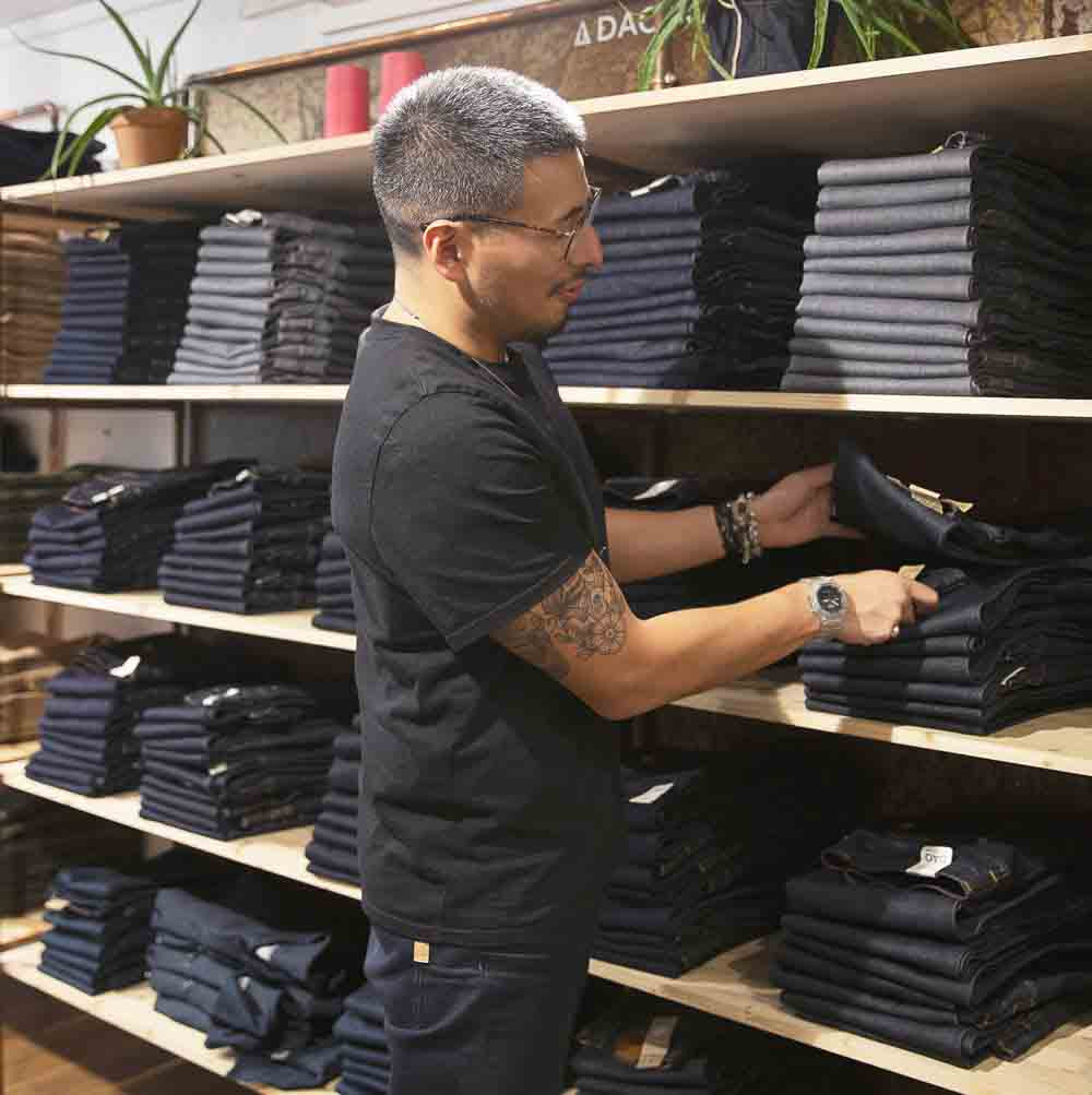 Thomas, responsable de la boutique Dao à Nancy en train de ranger nos jeans made in france