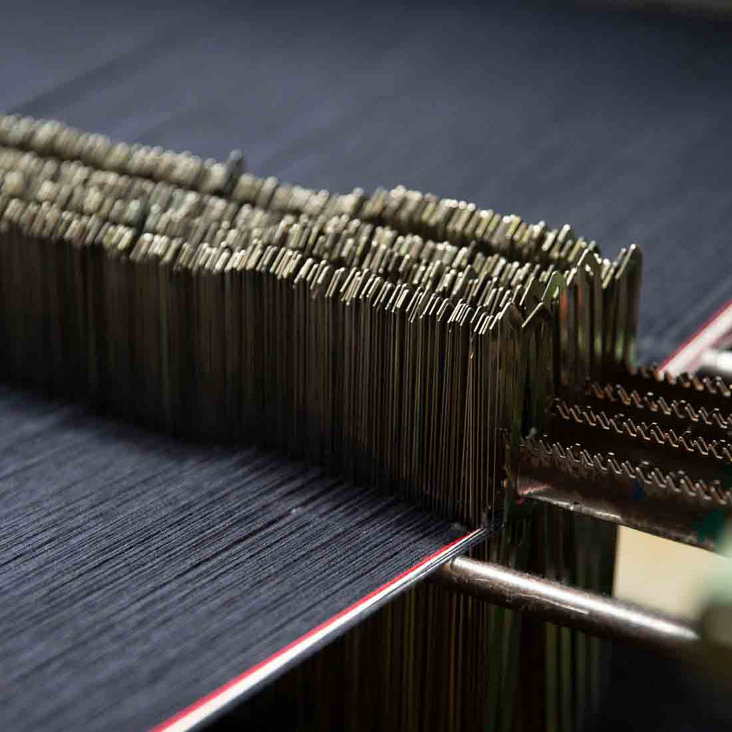 Etape du tissage du tissu selvedge Français de Dao. Les fils sont passé entre des lisses