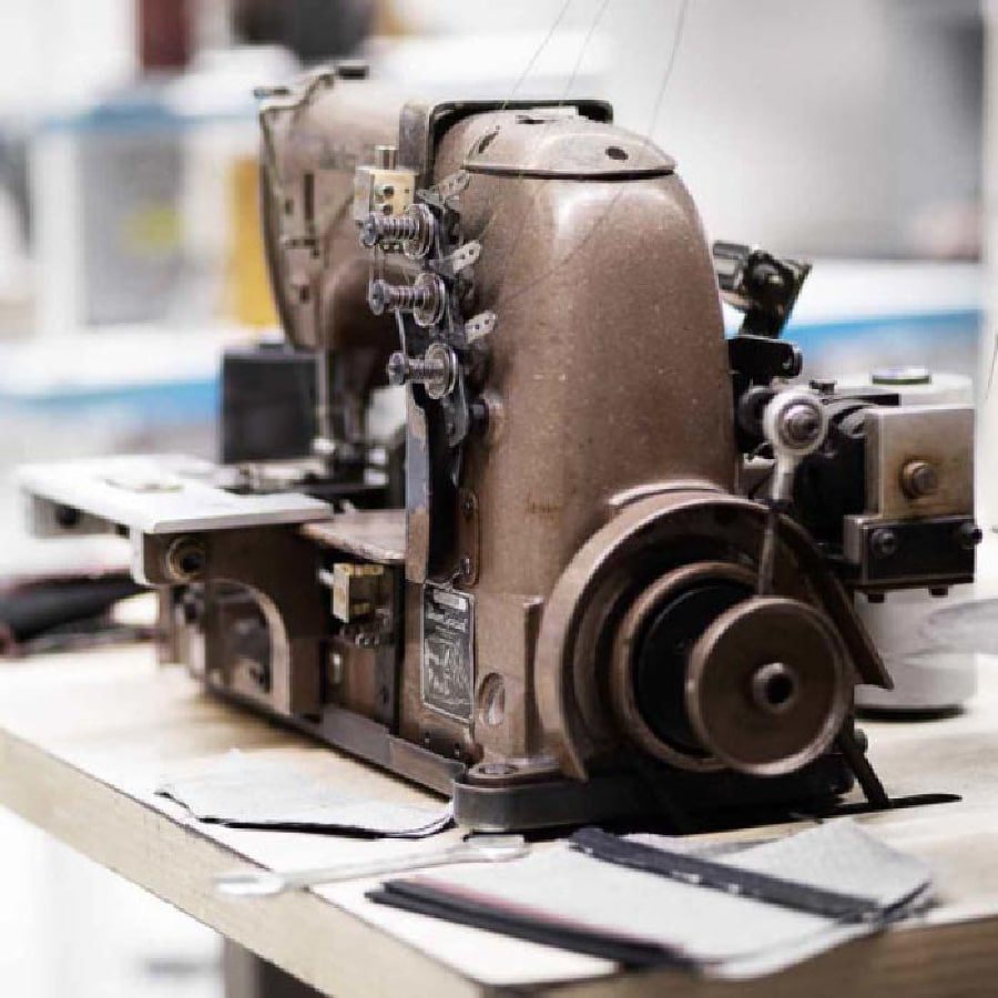  gros plan machine à passant industrielle vintage à l'atelier DAO Jeans Made in France